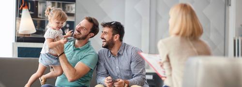Two men holding a girl talking to a professional