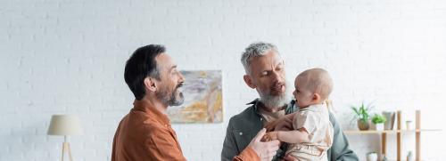 Two fathers getting baby from crib
