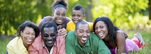 2 man, 2 woman, a girl and a boy laying on the grass, smiling